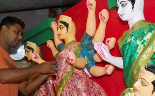 An Artist of Kumartuli finishing touch at a Durga idol made by Shola (Pith) for Overseas country in Kolkata