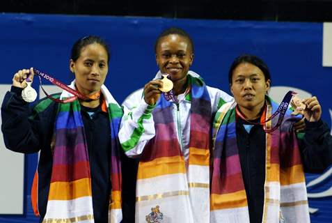 The winner of first Gold medal of the 19th Commonwealth Games, Nigeria's Augustina Nkem (center) with India's  Siver medal winner Sonia Chanu (left)  and Bronze medal winner Sandhya Rani devi(Right) at the 48-kg category womens weightlifting