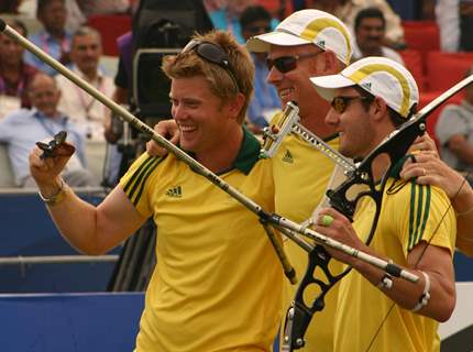 Gold medallists  Mat Masonwells, Matthew Gray and Taylor Worth celebrate victory during the Men's Team Recurve event at the 19th Commonwealth Games