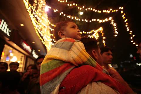 Kolkata: A child enjoys the ride of his father's soulder during the eve of up coming New Year 2011 in Kolkata on Wednesday. .