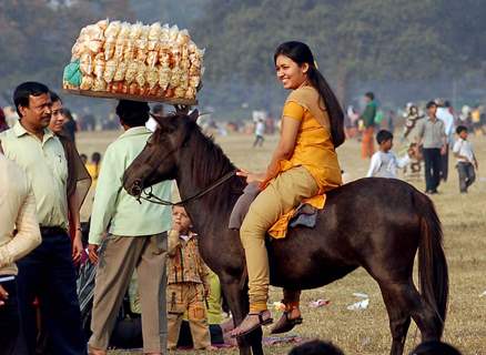 A lady tourist enjoys horse ride during the first day of New Year 2011 in Kolkata Maidan on Saturday. .