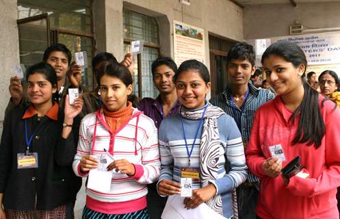 Young voters with their voter ID cards at a election centres in New ...