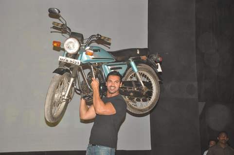 John Abraham holds up bike during the promotion of their film 'Force' in Mumbai