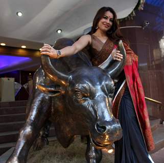 Mahima Chaudhary poses with a bronze statue of a bull after taking part in the Diwali Muhurat Tradin