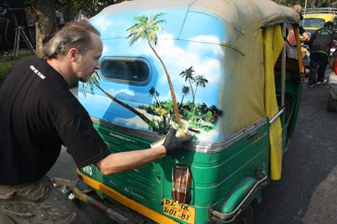 German graffiti artist Jens Tasso Muller spray painting on  an auto rickshaw outside the German Embassy  to celebrate 60 years of Indo-German diplomatic relations ,in New Delhi on Thursday. .