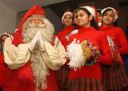 Celebrating the spirit of Christmas the official Santa Claus from Lapland ,Finland with coral singing girls at Le Meridien ,in New Delhi. .