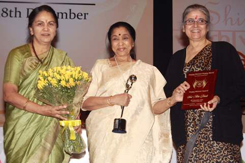 Asha Bhosle receiving award from Justice Gyan Sudha Misra and Justice Ranjana Desai on &quot;Happy Woman's Day&quot; celebration at Balayogi Auditorium at Parliament House in New Delhi. (Photo: IANS/Amlan)