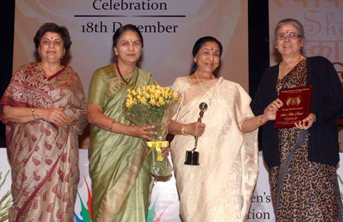 Asha Bhosle receiving award from Justice Gyan Sudha Misra and Justice Ranjana Desai on &quot;Happy Woman's Day&quot; celebration at Balayogi Auditorium at Parliament House in New Delhi. (Photo: IANS/Amlan)