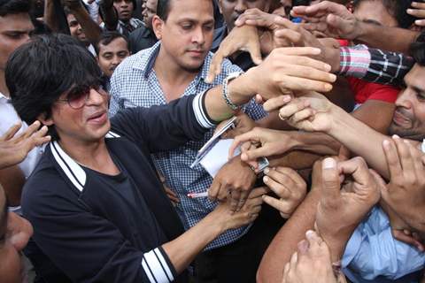 Fans crowd around Shahrukh Khan as he arrives at Big Cinemas