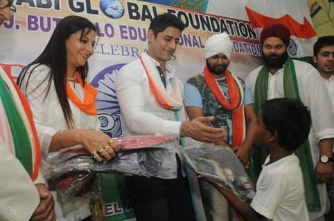 Mohit Raina distributes school bags among the children from the orphanage