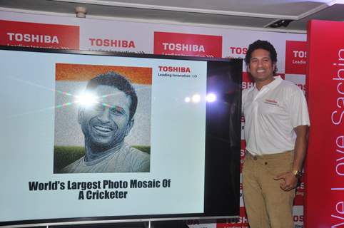 Sachin Tendulkar poses with his portrait at the launch 'WeAreSachin' campaign