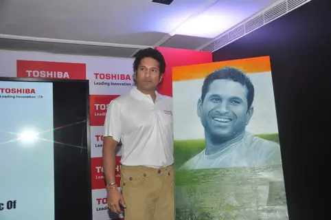 Sachin Tendulkar poses with his portrait at the launch 'WeAreSachin' campaign