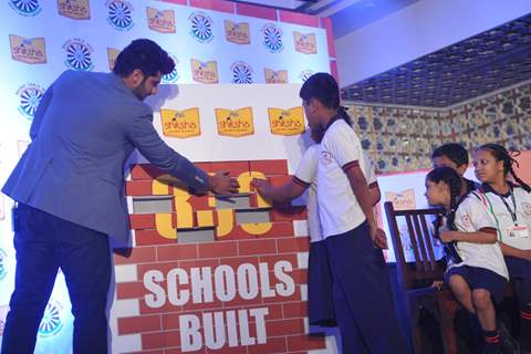 Arjun Kapoor helps the children solve a puzzle at a P&G Shiksha event