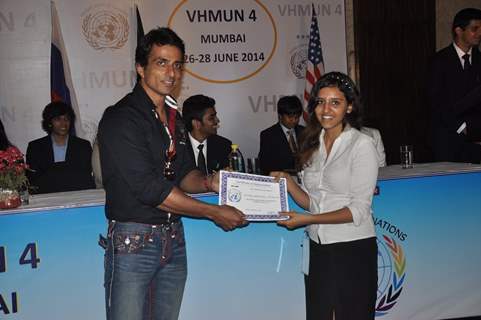 Sonu Sood giving certificate to student at MUNA event.