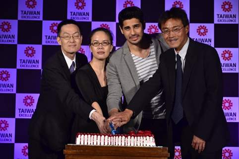 Sidharth Malhotra cutting the cake with the Taiwan Excellence representatives