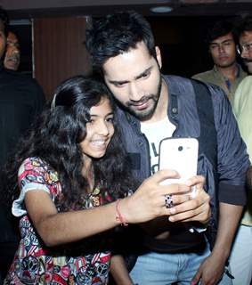 Varun poses for a selfie with a young fan