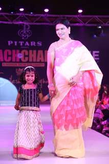 A guest with a child walk the ramp at the Teach for Change 2014 Fashion Show