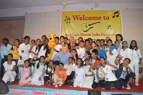 Leslie Lewis and Brett Lee pose with kids at Brett Lee's Mewsic India Foundation