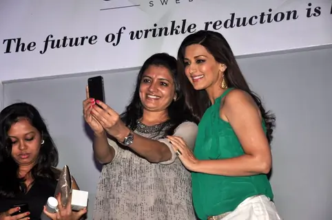 Sonali Bendre poses with a fan for a selfie at the Launch of Orliflame Products