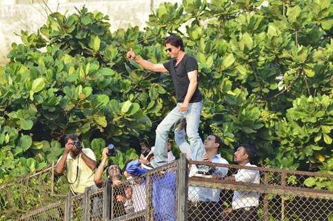 Shahrukh Khan climbs over the railing to greet his fans