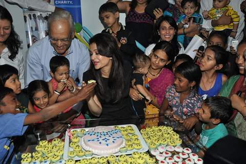 Children feed cake to Aishwarya Rai Bachchan at Smile Train Organisation