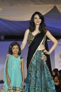 Saumya Tandon walks the ramp with a small girl at Wellingkar's 26/11 Tribute