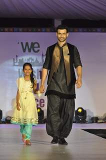 Freddy Daruwala walks the ramp with a small girl at Wellingkar's 26/11 Tribute