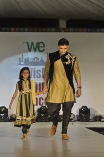 Sangram Singh walks the ramp with a small girl at Wellingkar's 26/11 Tribute