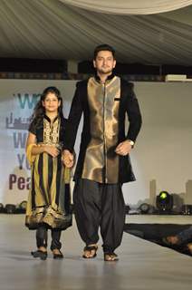 Shaad Randhawa walks the ramp with a small girl at Wellingkar's 26/11 Tribute