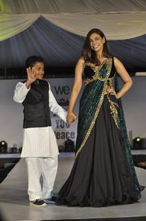 Lisa Ray walks the ramp with a small boy at Wellingkar's 26/11 Tribute