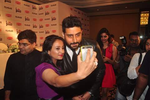 Abhishek Bachchan clicks a selfie with a guest at the Press Conference of 60th Filmfare Awards 2014