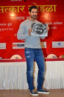 John Abraham poses with the Book 'In Search Of Dignity And Justice' at the Launch