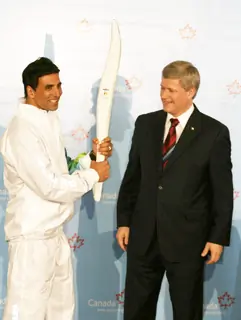 Canadian Prime Minister Stephen Harper and Bollywood Actor Akshay Kumar pose with a jacket, which will be worn by torchbearers for the 2010 Winter Olympics torch relay during an event at Trident in Mumbai on Monday, 16 November 2009