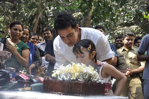 Aamir KHan blows his 45rd birthday candles with one of his child fans as he celebrated his birthday with media today at his home in Mumbai