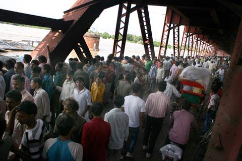 People watching overflowing Yamuna River at old bridge in  Delhi on Saturday