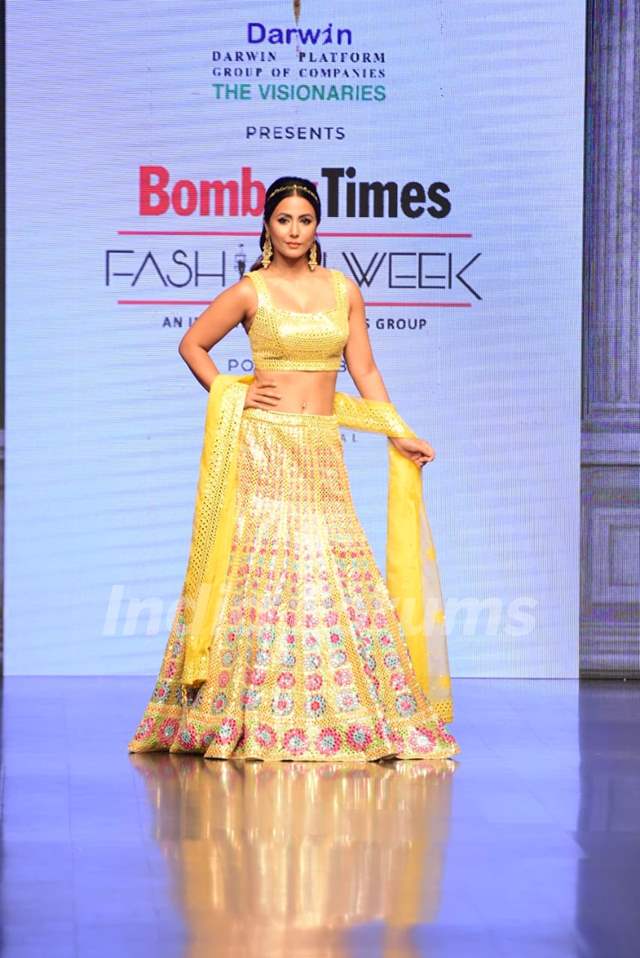 Hina Khan twirling with joy in a yellow lehenga at the Bombay Times Fashion Week
