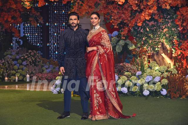 Deepika Padukone looked ethereal in a red saree, embroidered blouse and a choker set while Ranveer Singh wore a navy blue jacket, paired with matching kurta and trousers.