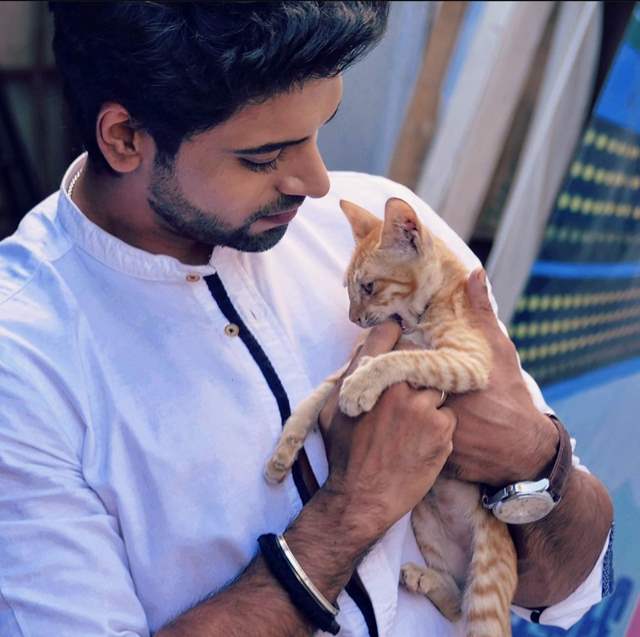 Aakash Ahuja with a cat on the sets of Faltu