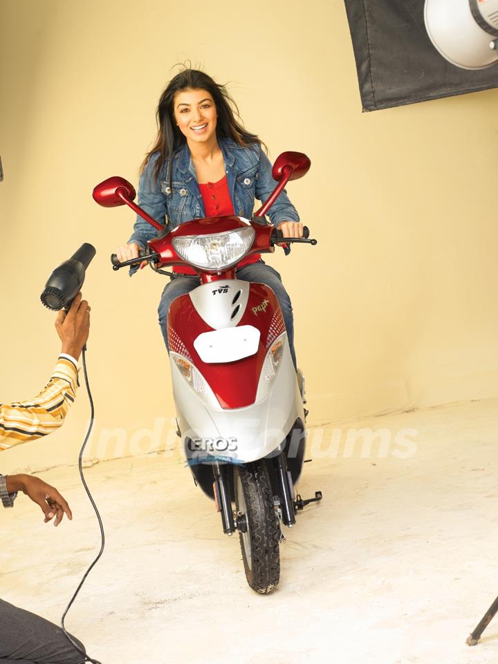 Ayesha Takia sitting on a scooty