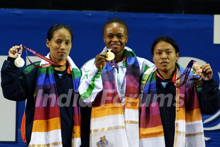 The winner of first Gold medal of the 19th Commonwealth Games, Nigeria's Augustina Nkem (center) with India's  Siver medal winner Sonia Chanu (left)  and Bronze medal winner Sandhya Rani devi(Right) at the 48-kg category womens weightlifting