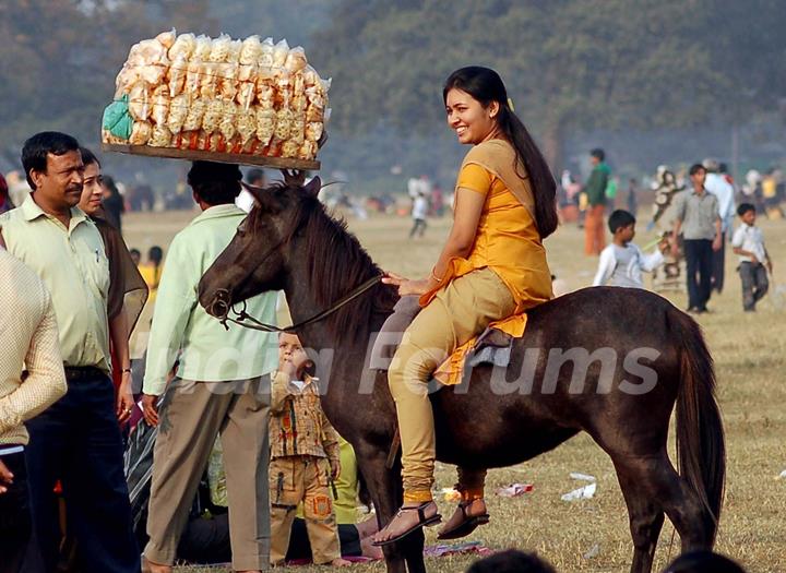 A lady tourist enjoys horse ride during the first day of New Year 2011 in Kolkata Maidan on Saturday. .