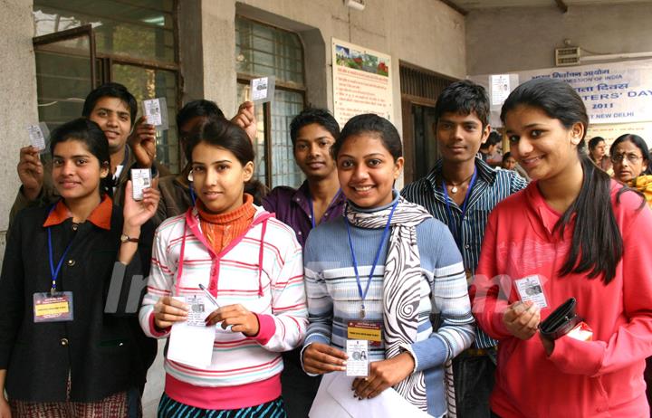 Young voters with their voter ID cards at a election centres in New Delhi on Tuesday. In order to encourage more young voters to take part in the political process, Government has decided to celebrate January 25 every year as 'National Voters' Day. .