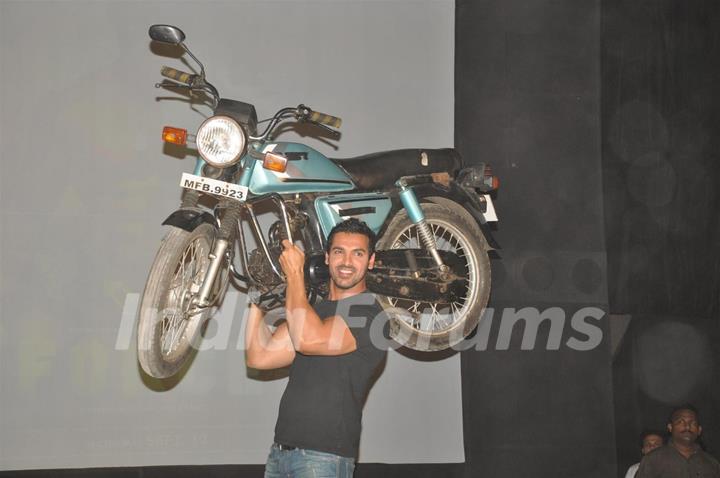 John Abraham holds up bike during the promotion of their film 'Force' in Mumbai