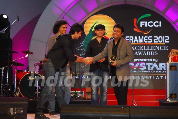 Ranbir Kapoor, Imtiaz Ali and Mohit Chauhan present AR Rahman with an award at the FICCI Frames Excellence Awards 2012. .