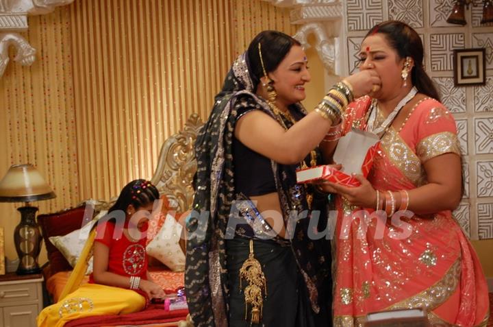 Manjula giving sweet to Parul in Hamari Devrani