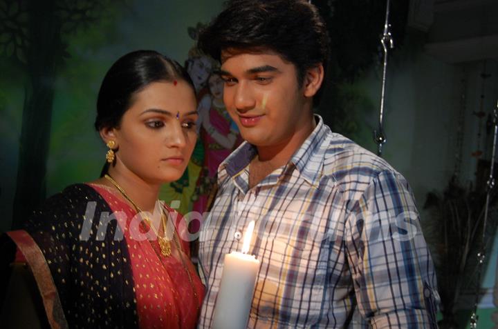 Mohan and Bhakti standing with a candle