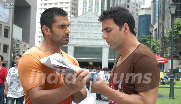 Sunil Shetty showing news to Akshay Kumar