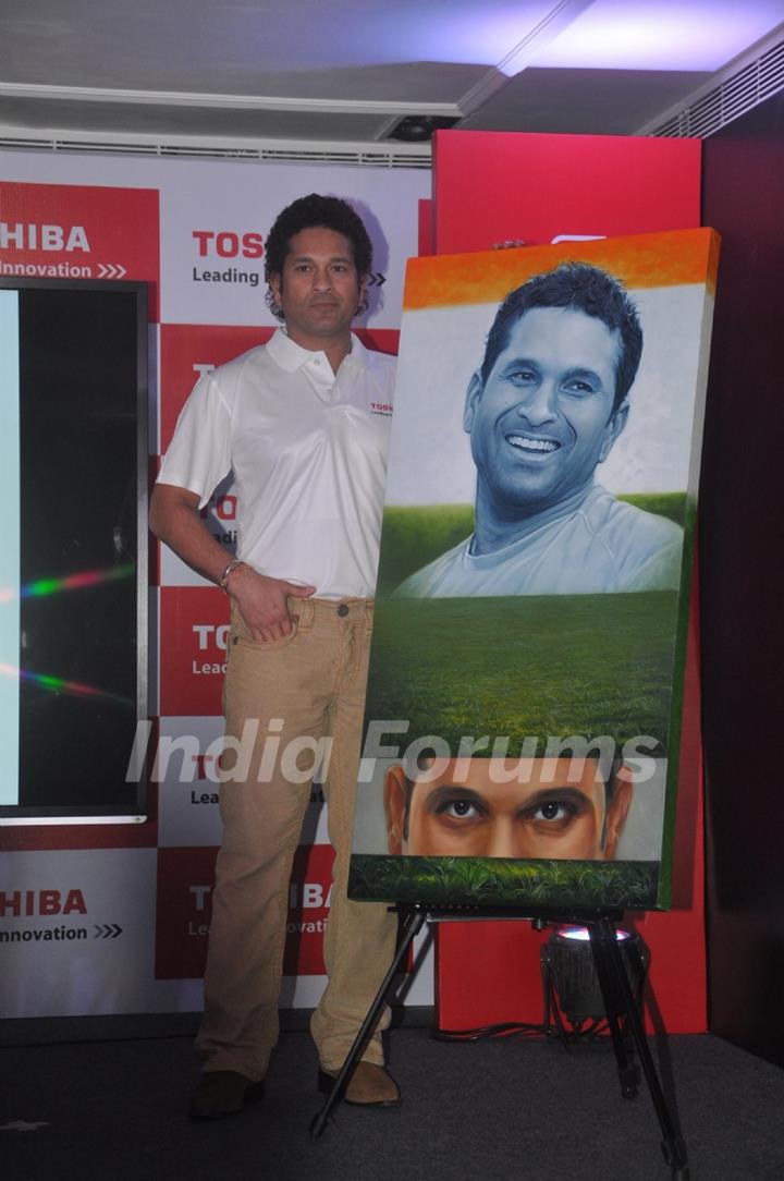 Sachin Tendulkar poses with his portrait at the launch 'WeAreSachin' campaign