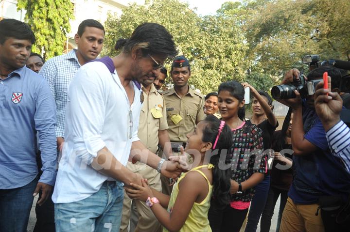 Shahrukh Khan interacts with a fan at a polling station in Mumbai