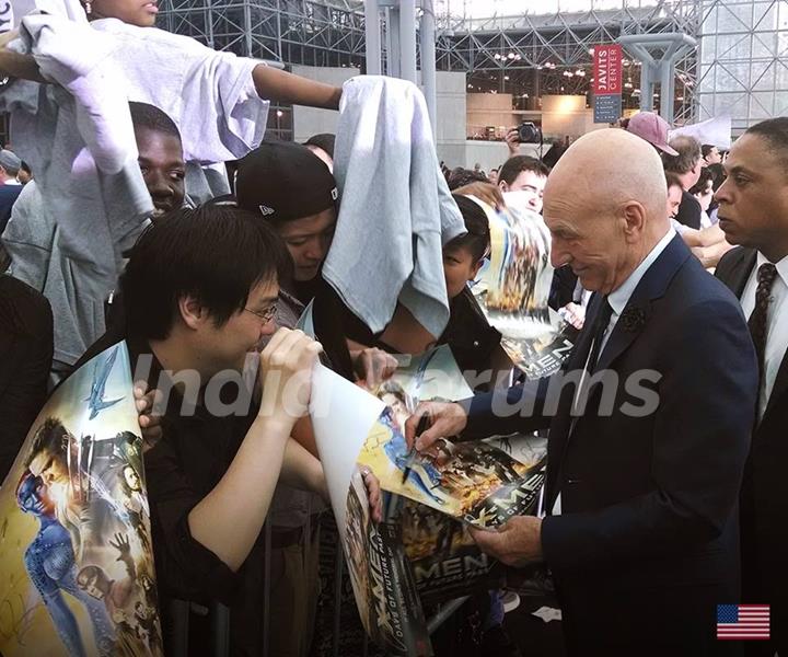 Patrick Stewart signs posters for his fans at the Premiere